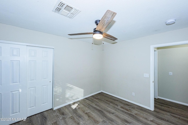 unfurnished bedroom featuring dark hardwood / wood-style flooring, a closet, and ceiling fan