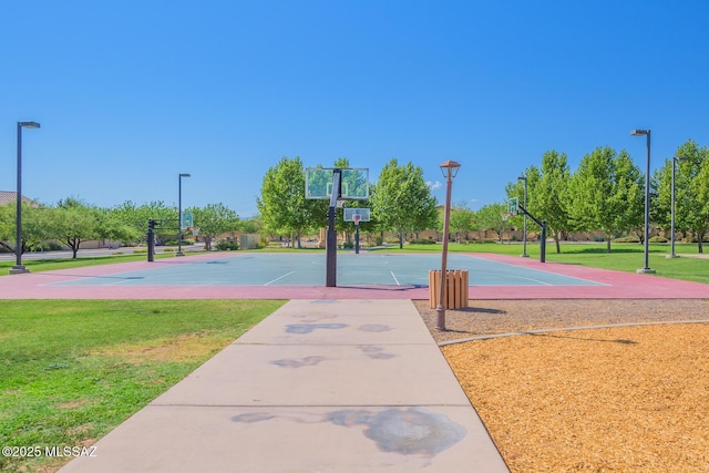 view of basketball court with a yard