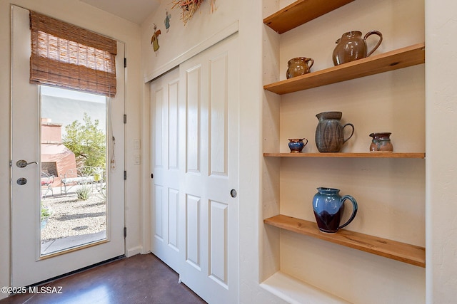 doorway featuring built in shelves and dark wood-type flooring