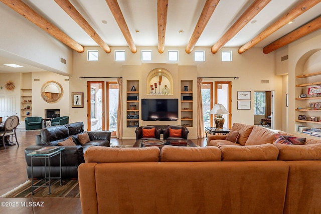 living room with built in shelves and a towering ceiling