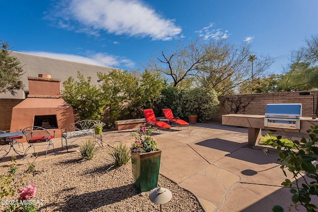 view of patio / terrace with a grill and exterior fireplace