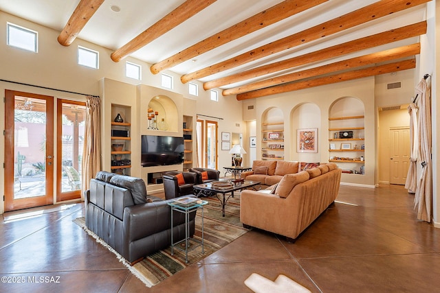 living room with built in shelves, finished concrete flooring, french doors, a towering ceiling, and beamed ceiling