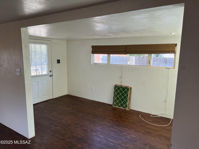 kitchen featuring white range with gas stovetop, stainless steel fridge, white cabinets, and a wall mounted air conditioner