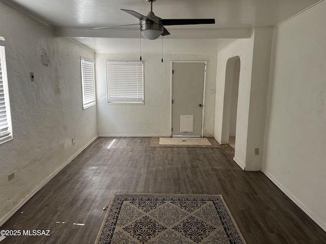 spare room featuring ceiling fan, dark wood-type flooring, and ornamental molding