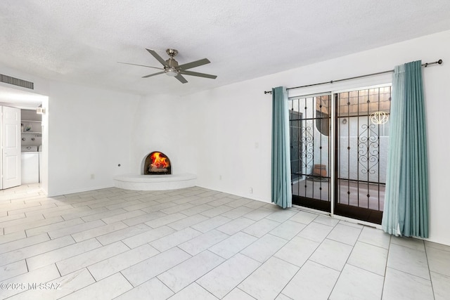 tiled empty room with ceiling fan and a textured ceiling