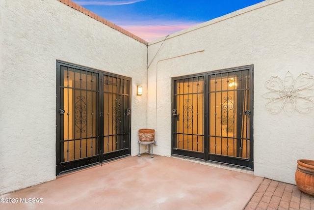 exterior entry at dusk with a patio