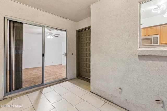 doorway with light tile patterned flooring and a textured ceiling