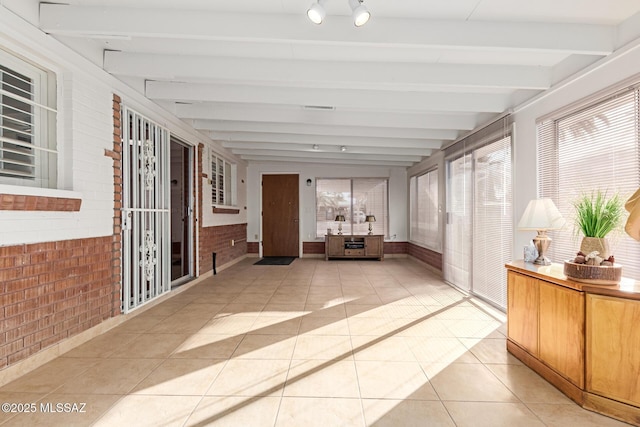 unfurnished sunroom featuring beamed ceiling