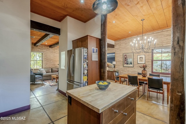 kitchen with pendant lighting, a center island, wooden ceiling, stainless steel fridge, and a chandelier