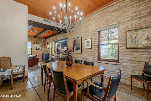 dining space featuring a healthy amount of sunlight, a notable chandelier, wooden ceiling, and brick wall