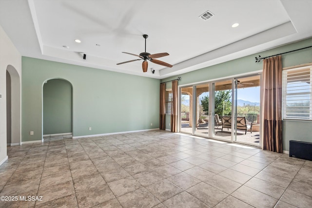 tiled spare room featuring ceiling fan, french doors, and a tray ceiling