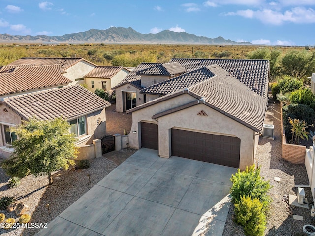 view of front of house featuring a garage, central AC, and a mountain view