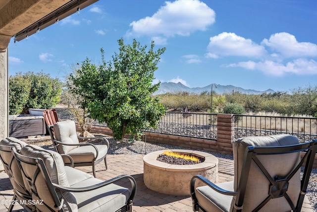 view of patio / terrace with a fire pit and a mountain view