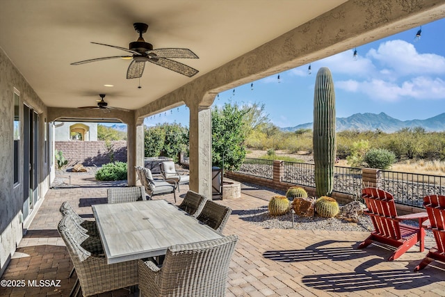 view of patio / terrace featuring ceiling fan and a mountain view