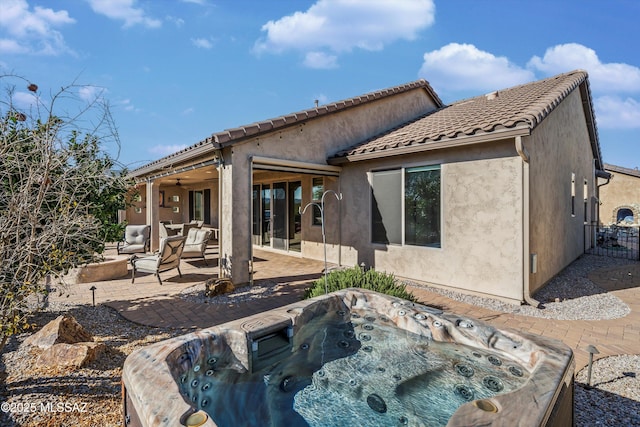 back of house featuring a patio and a hot tub