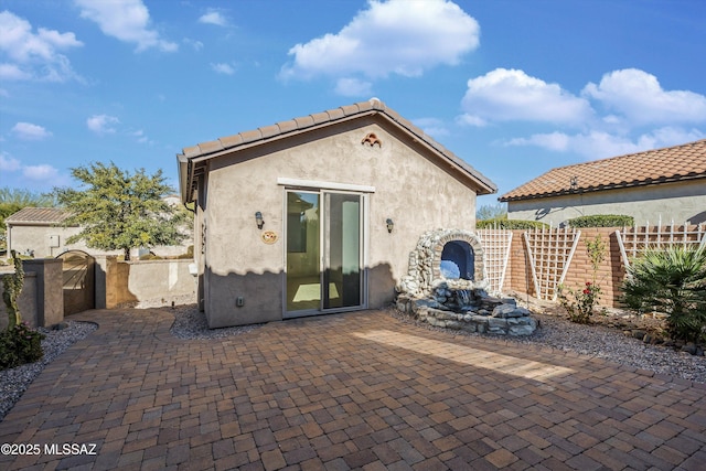 back of property featuring a patio area and an outdoor structure