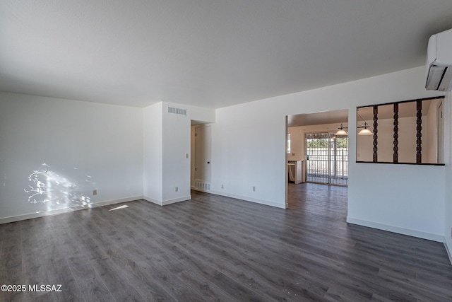 spare room with dark hardwood / wood-style flooring and a wall mounted AC