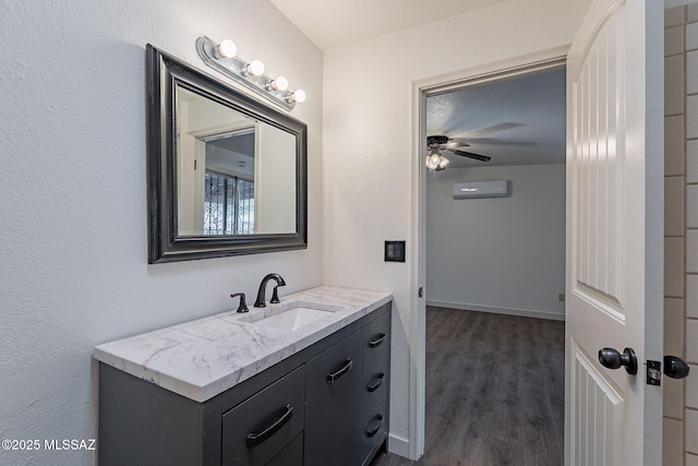 bathroom featuring ceiling fan, hardwood / wood-style floors, vanity, and a wall mounted air conditioner