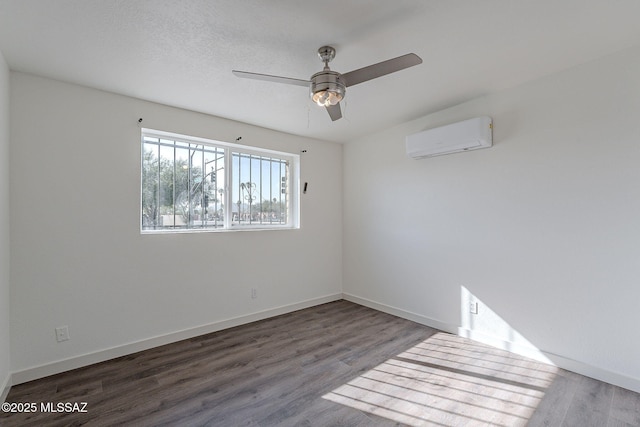 spare room featuring an AC wall unit, ceiling fan, and dark wood-type flooring