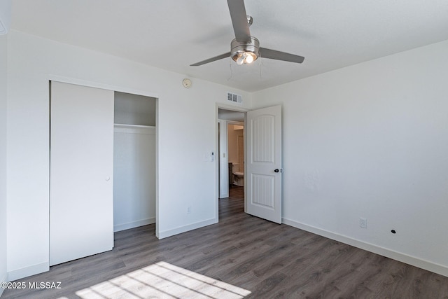 unfurnished bedroom with ceiling fan, a closet, and dark wood-type flooring