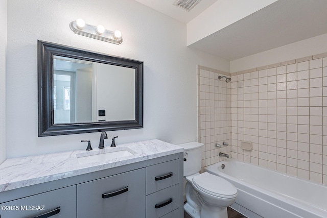 full bathroom featuring toilet, vanity, and tiled shower / bath combo