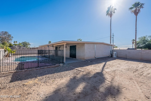 back of property with a fenced in pool and a patio