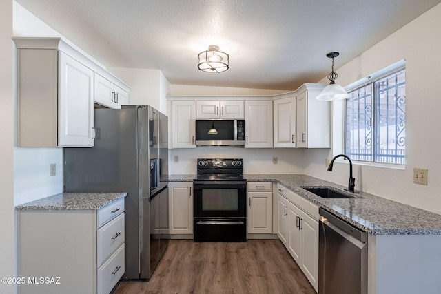 kitchen featuring sink, stainless steel appliances, dark hardwood / wood-style floors, decorative light fixtures, and white cabinets