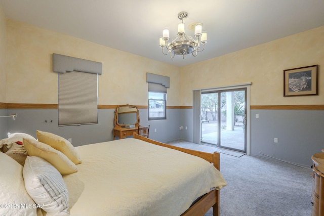 carpeted bedroom featuring a notable chandelier and access to outside