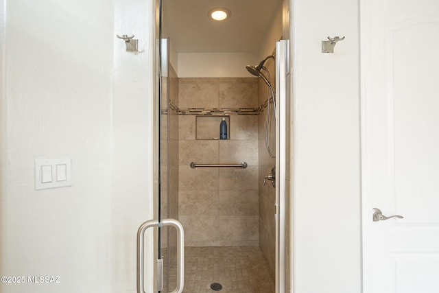 bathroom featuring a shower with shower door