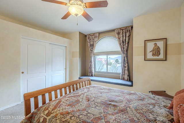 carpeted bedroom featuring ceiling fan and a closet