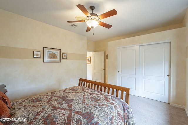 carpeted bedroom featuring ceiling fan and a closet