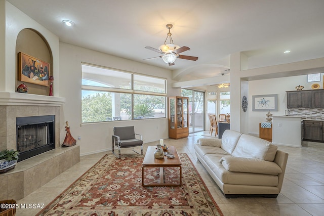 tiled living room featuring a tile fireplace and ceiling fan