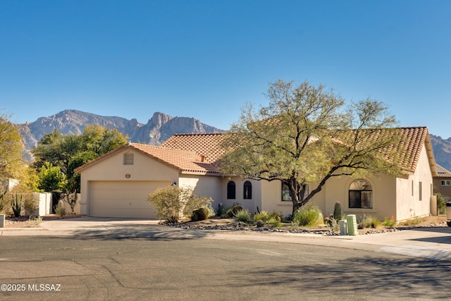 mediterranean / spanish-style home with a mountain view and a garage