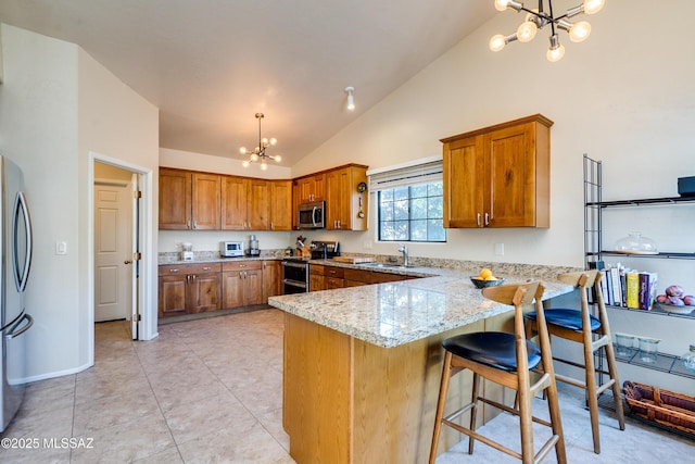 kitchen featuring appliances with stainless steel finishes, pendant lighting, a chandelier, and kitchen peninsula