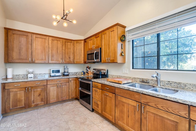 kitchen with lofted ceiling, sink, appliances with stainless steel finishes, hanging light fixtures, and light stone counters