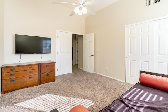 bedroom featuring ceiling fan, high vaulted ceiling, a closet, and light carpet