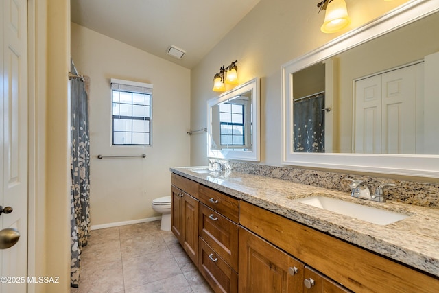 bathroom featuring vaulted ceiling, vanity, tile patterned floors, and toilet