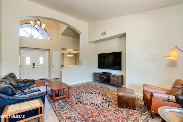 living room with a towering ceiling and an inviting chandelier