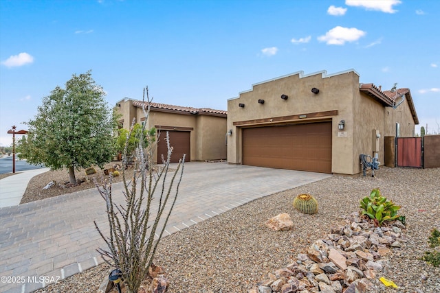 pueblo revival-style home featuring a garage