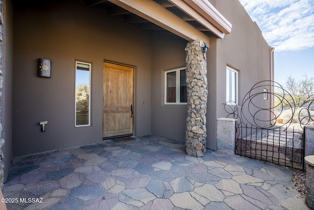 view of exterior entry with a patio area