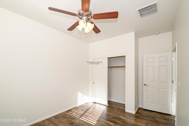 unfurnished bedroom featuring ceiling fan, dark wood-type flooring, and a closet