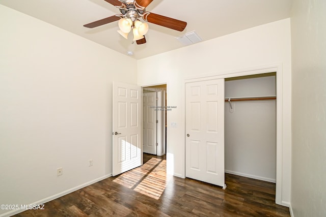 unfurnished bedroom with ceiling fan, dark wood-type flooring, and a closet