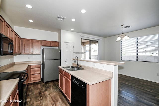 kitchen with a chandelier, black appliances, an island with sink, sink, and decorative light fixtures