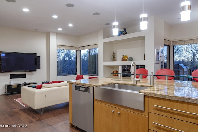 kitchen with pendant lighting, sink, stainless steel dishwasher, dark hardwood / wood-style floors, and light stone countertops