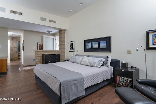 bedroom featuring ensuite bathroom and dark hardwood / wood-style flooring