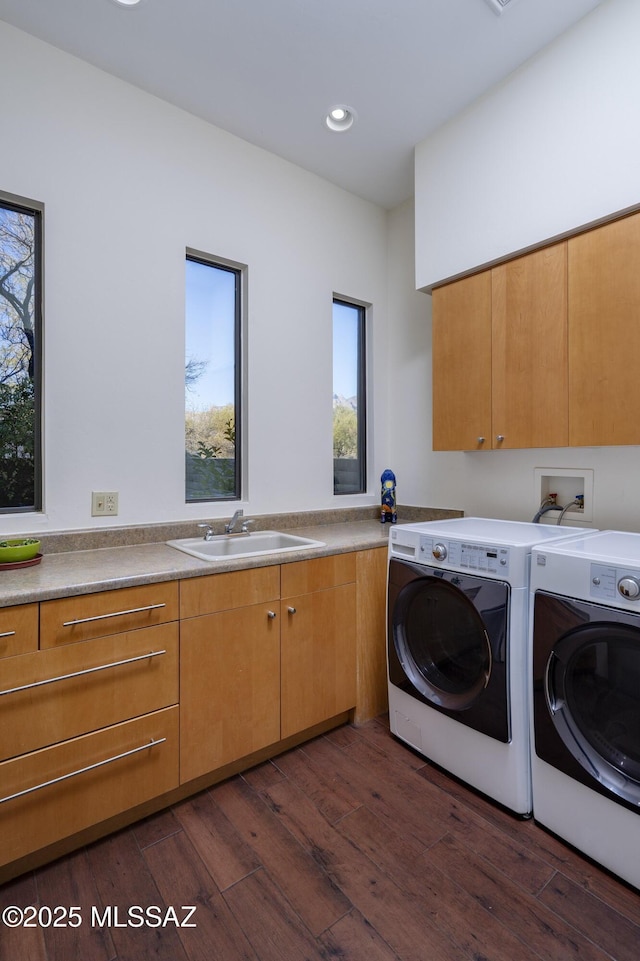 washroom with cabinets, dark hardwood / wood-style floors, washer and clothes dryer, and sink