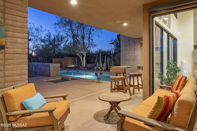 patio terrace at dusk featuring a fenced in pool