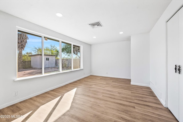 spare room featuring baseboards, recessed lighting, visible vents, and light wood-style floors