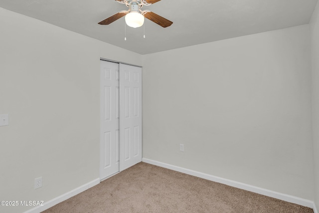 unfurnished bedroom featuring a closet, ceiling fan, and light colored carpet