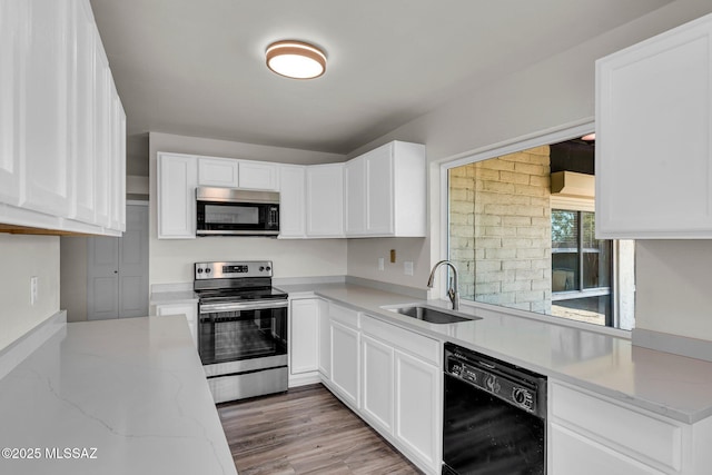 kitchen featuring stainless steel electric range, dishwasher, sink, light stone counters, and white cabinetry